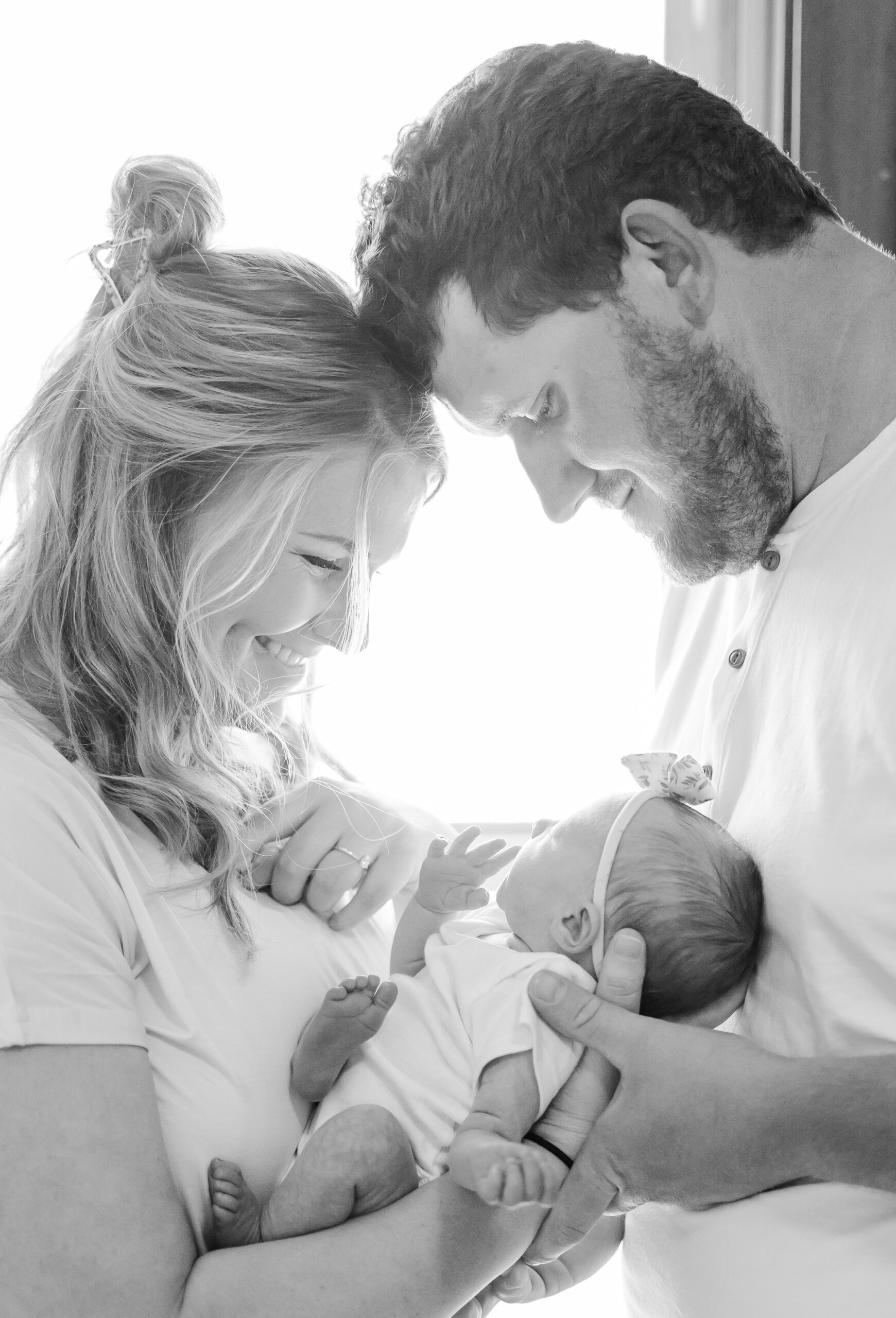 in-home newborn session photo of young couple and their newborn baby girl