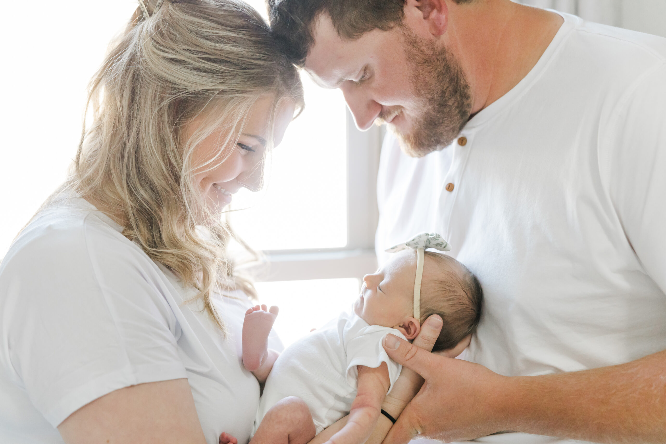 in-home newborn session photo of young couple and their newborn baby girl