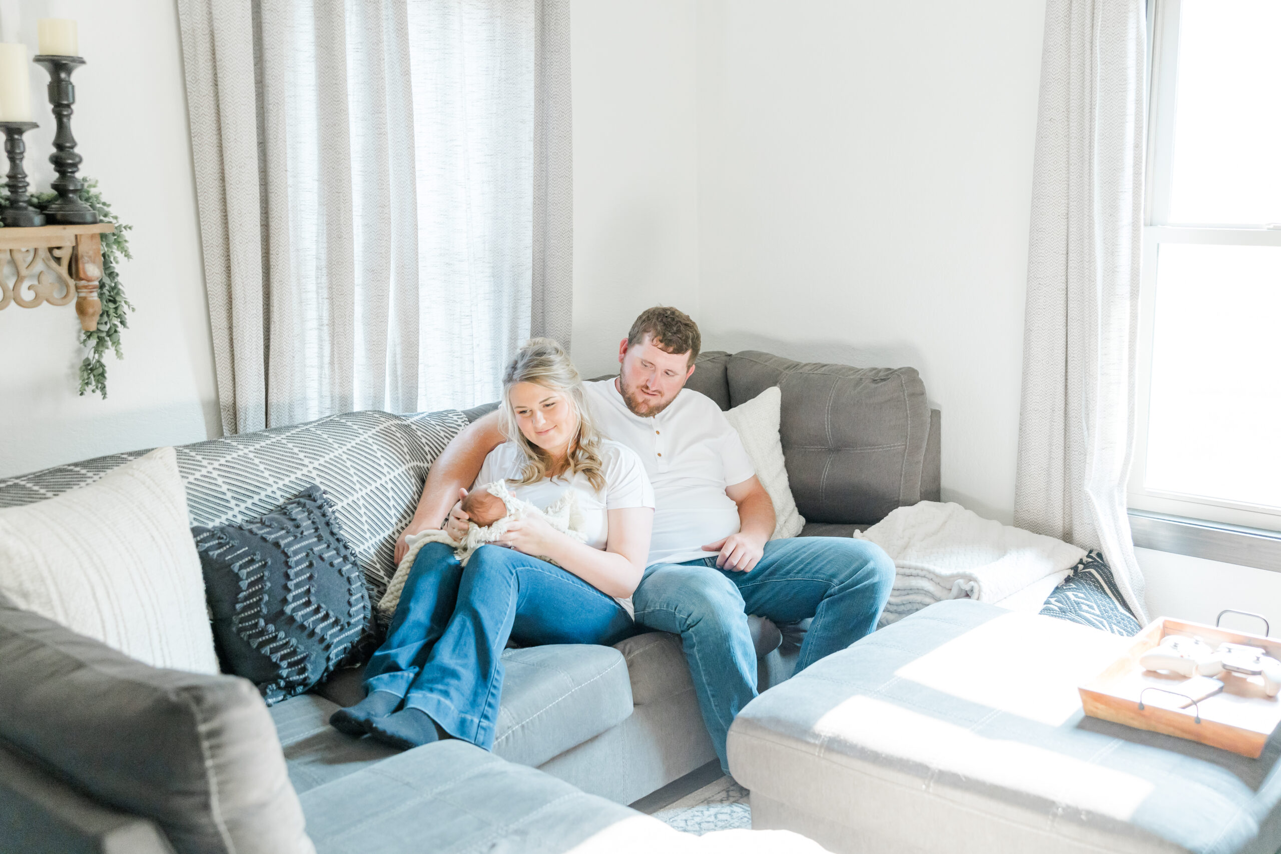 in-home newborn session photo of young couple and their newborn baby girl