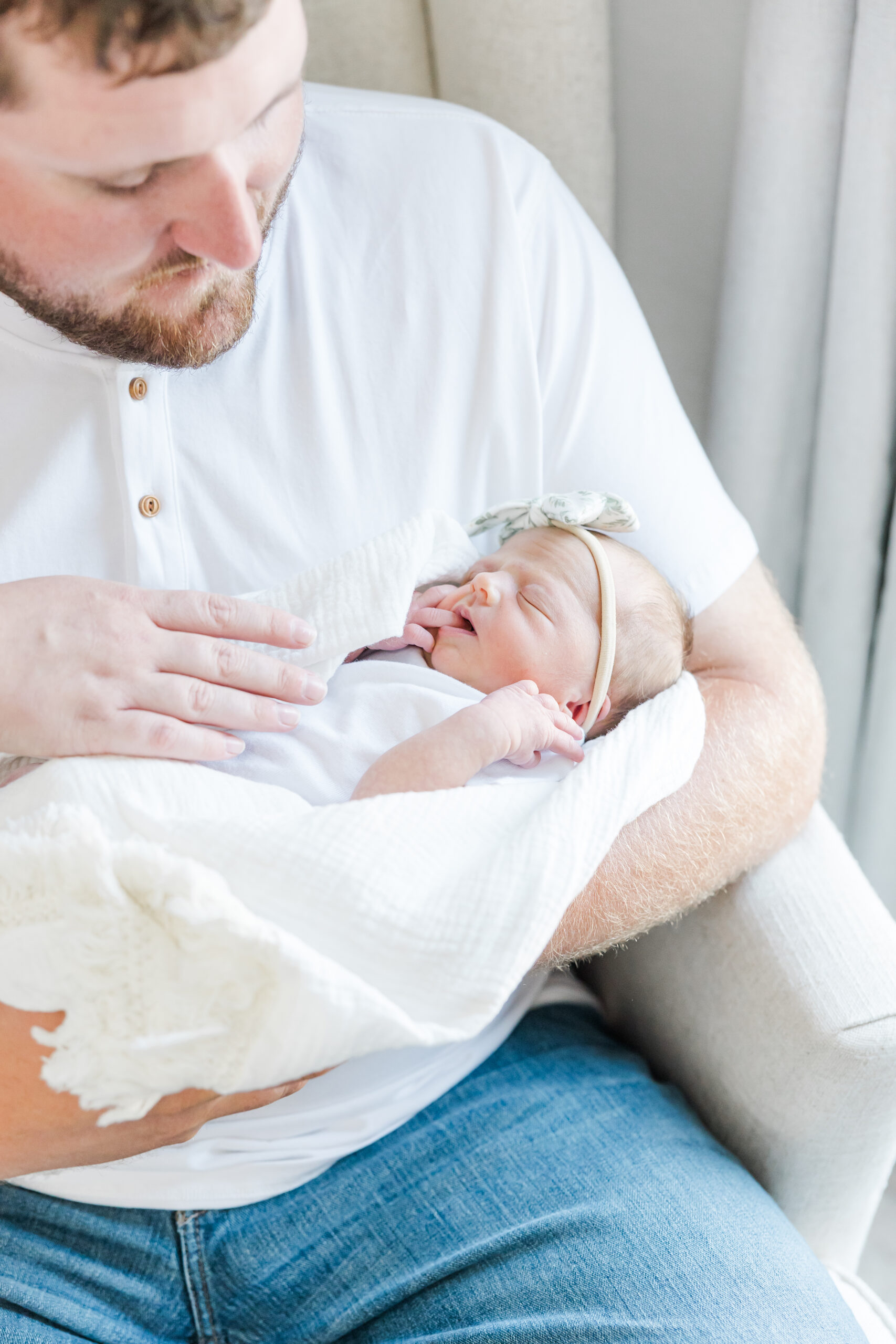 in-home newborn session photo of young couple and their newborn baby girl