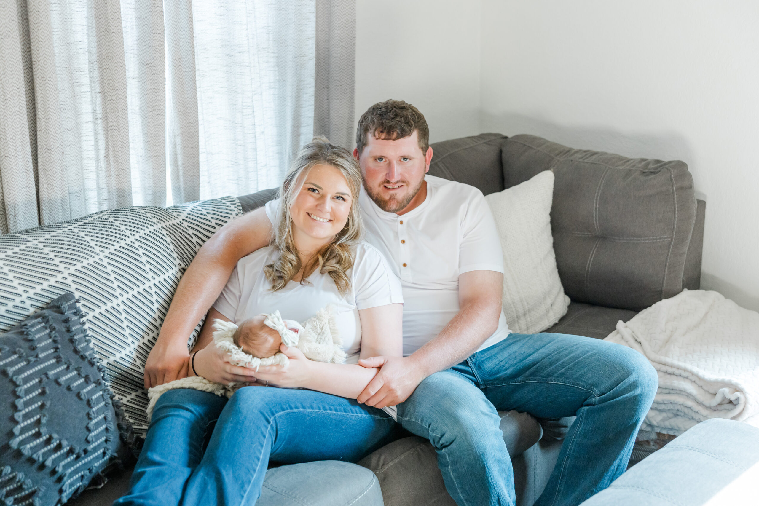 in-home newborn session photo of young couple and their newborn baby girl