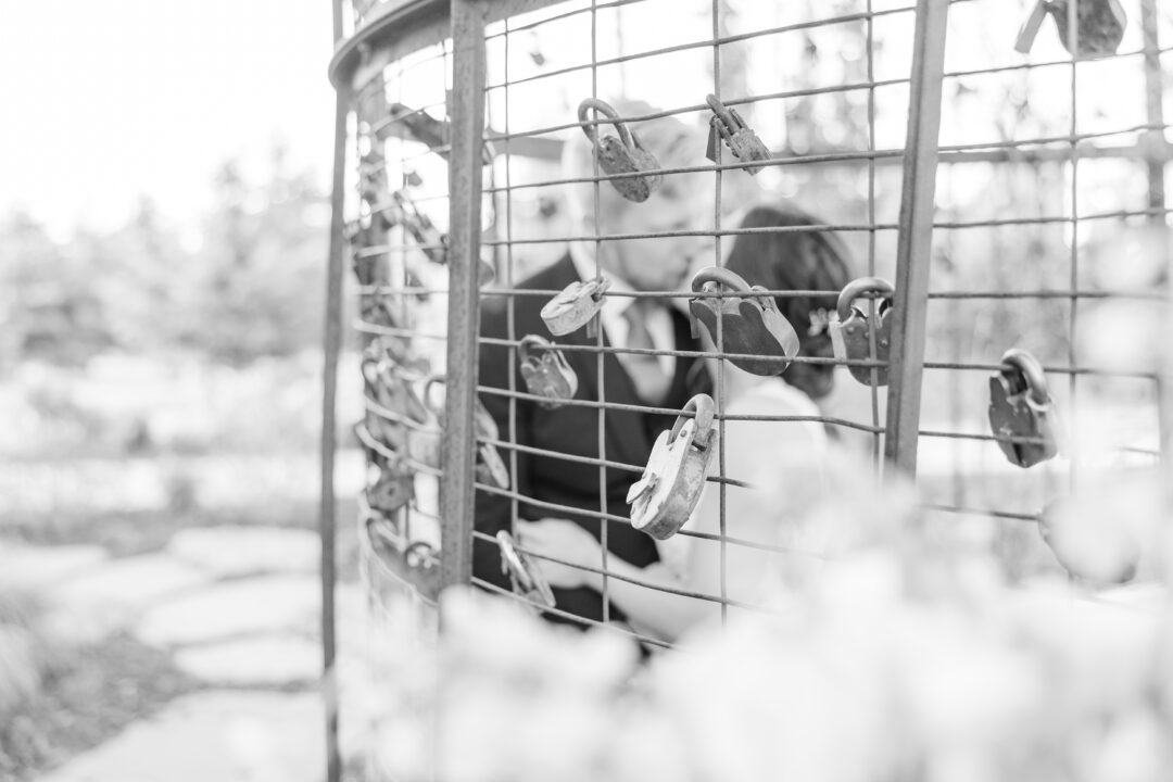 Bride and groom putting lock on silo love lock area.