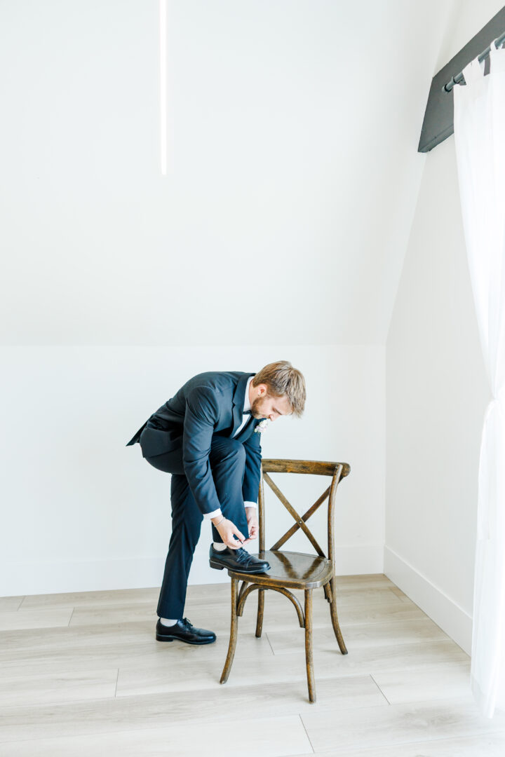 groom getting ready in A-frame airbnb at barn at aspen acres wedding